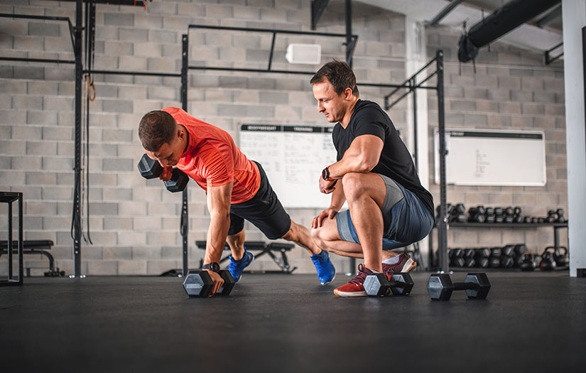 Early 30s Male Athlete Doing Renegade Row Push-Ups at Gym